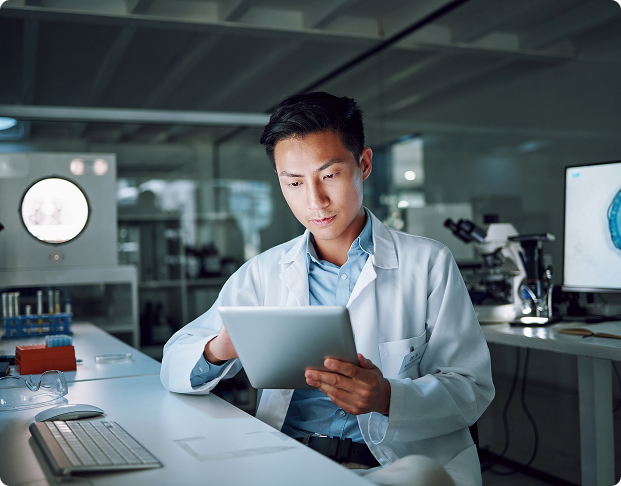 a doctor looks at a tablet working in a dark lab